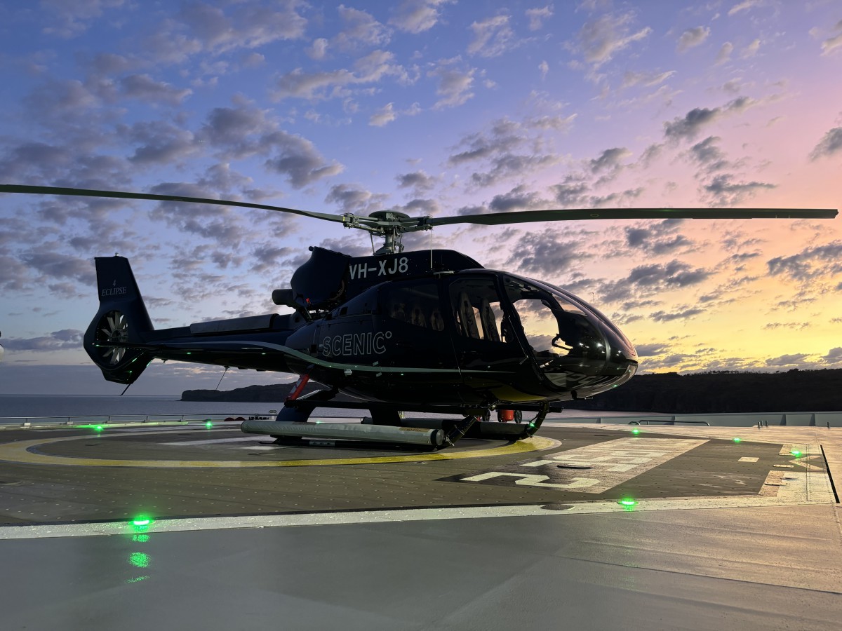 Helicopter parked on a helipad at sunset