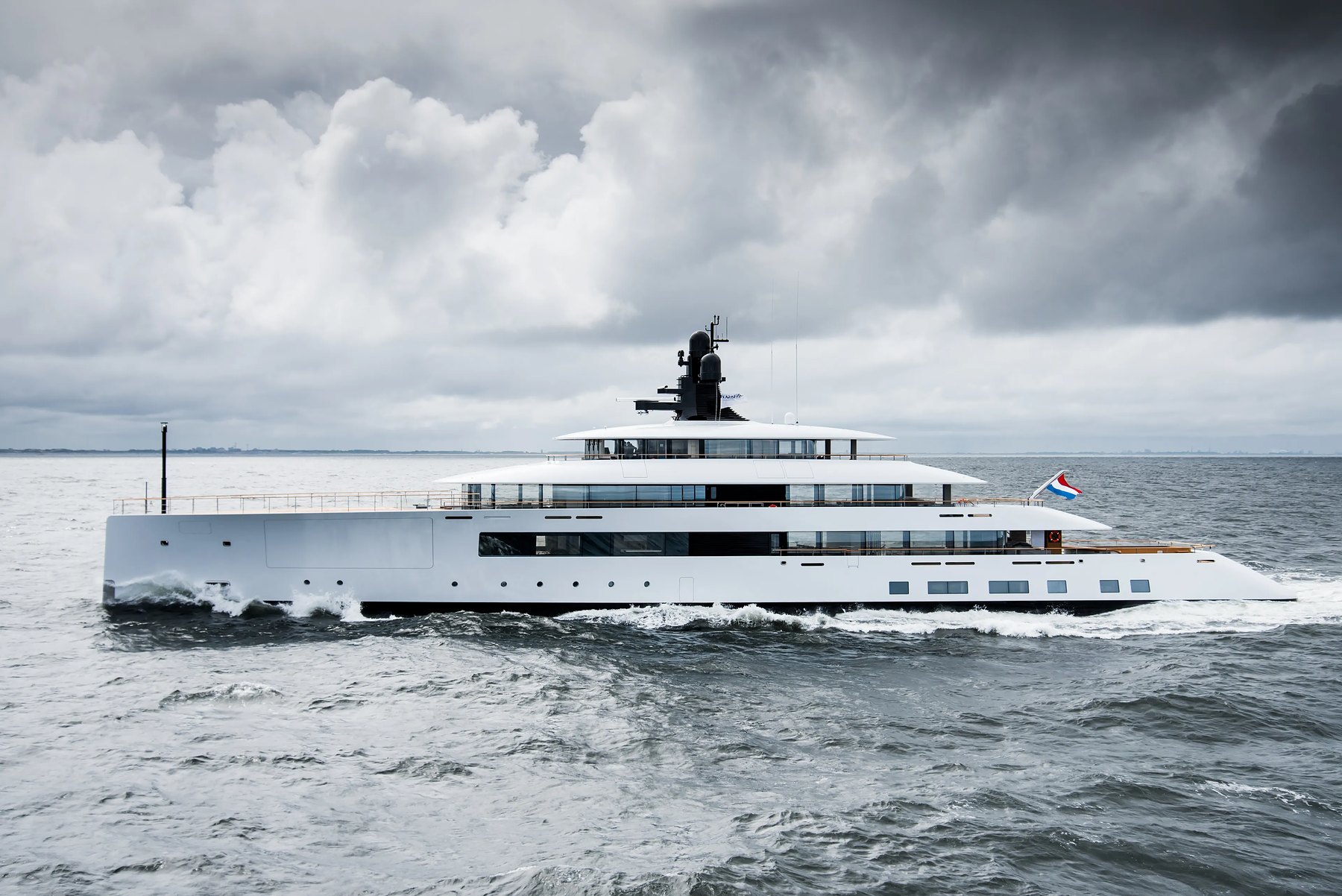 White superyacht at sea under heavy storm clouds